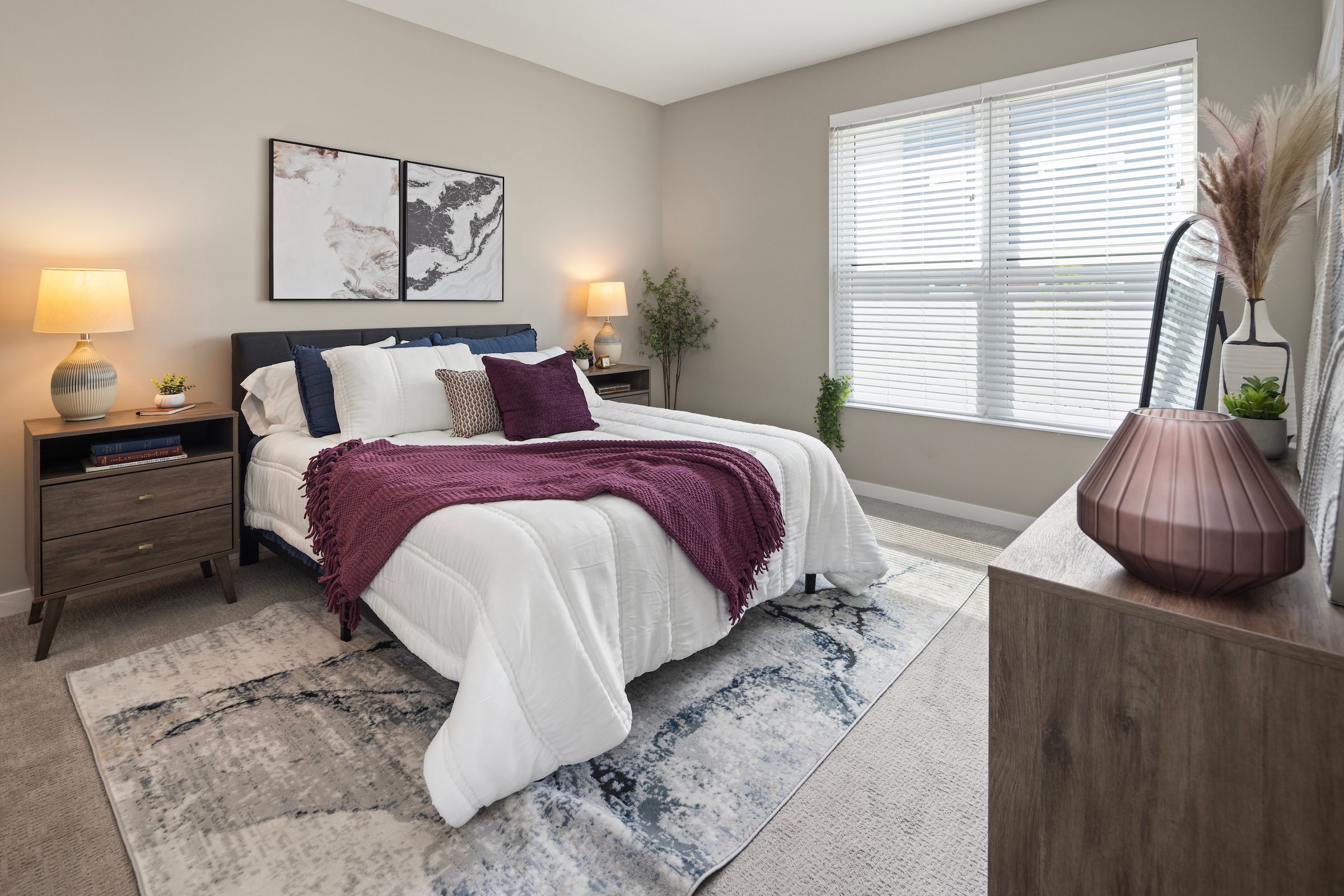 Slate apartment spacious bedroom with large windows and carpet flooring.