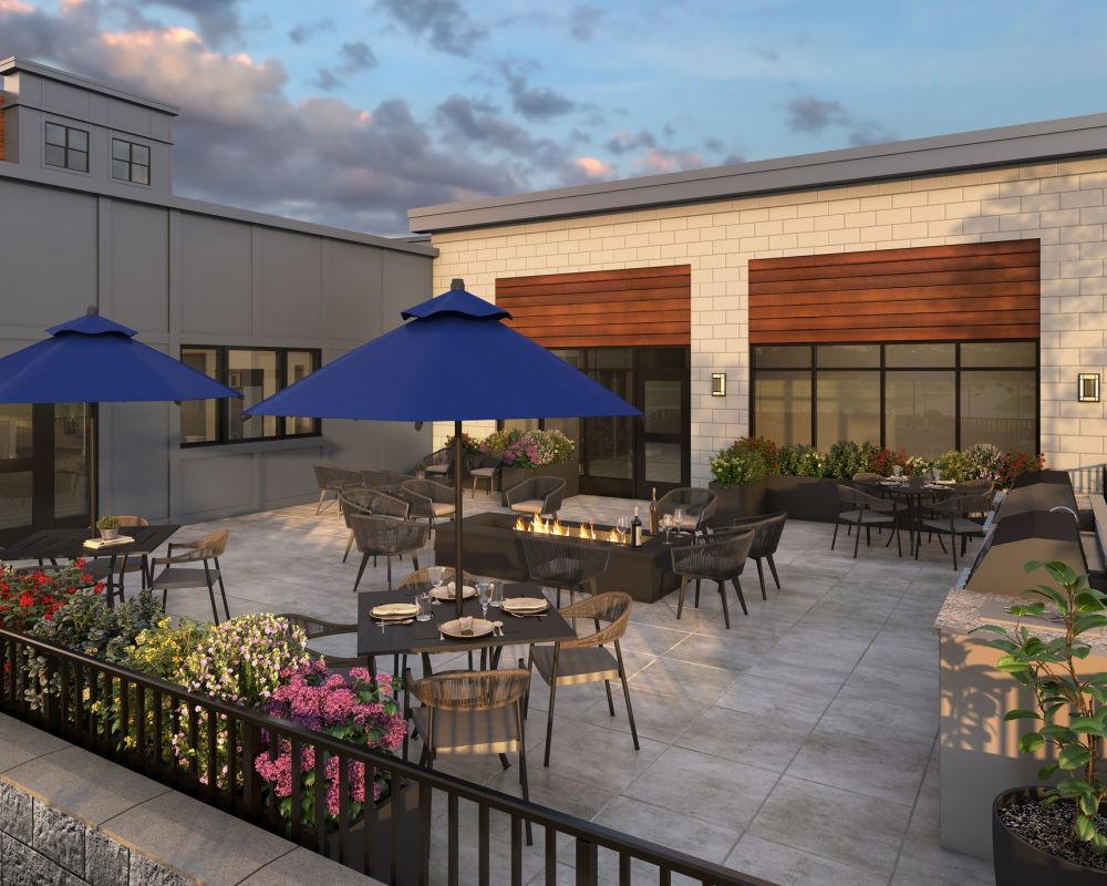 The Deck amenity at Slate 55+ Apartments with patio seating and umbrellas