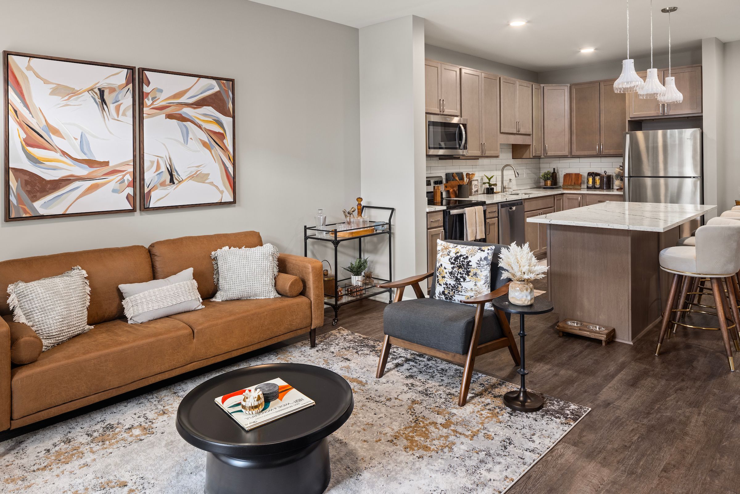 Slate property's sleek kitchen showcasing taupe cabinetry, white subway tile backsplash, and marble countertops.