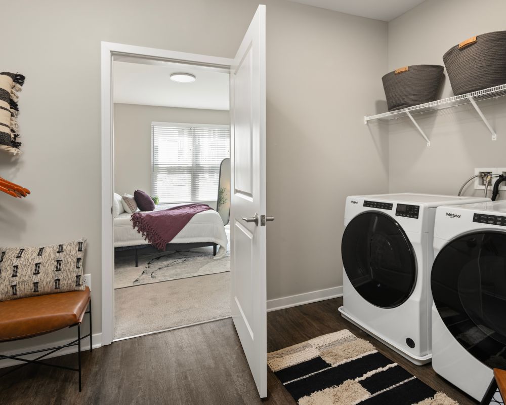 Slate apartment large laundry room with energy efficient washer and dryer and built-in shelves