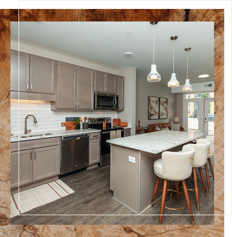 active senior 55+ apartment showing large kitchen island, pendant lighting, elegant cabinetry, and stainless steel appliances