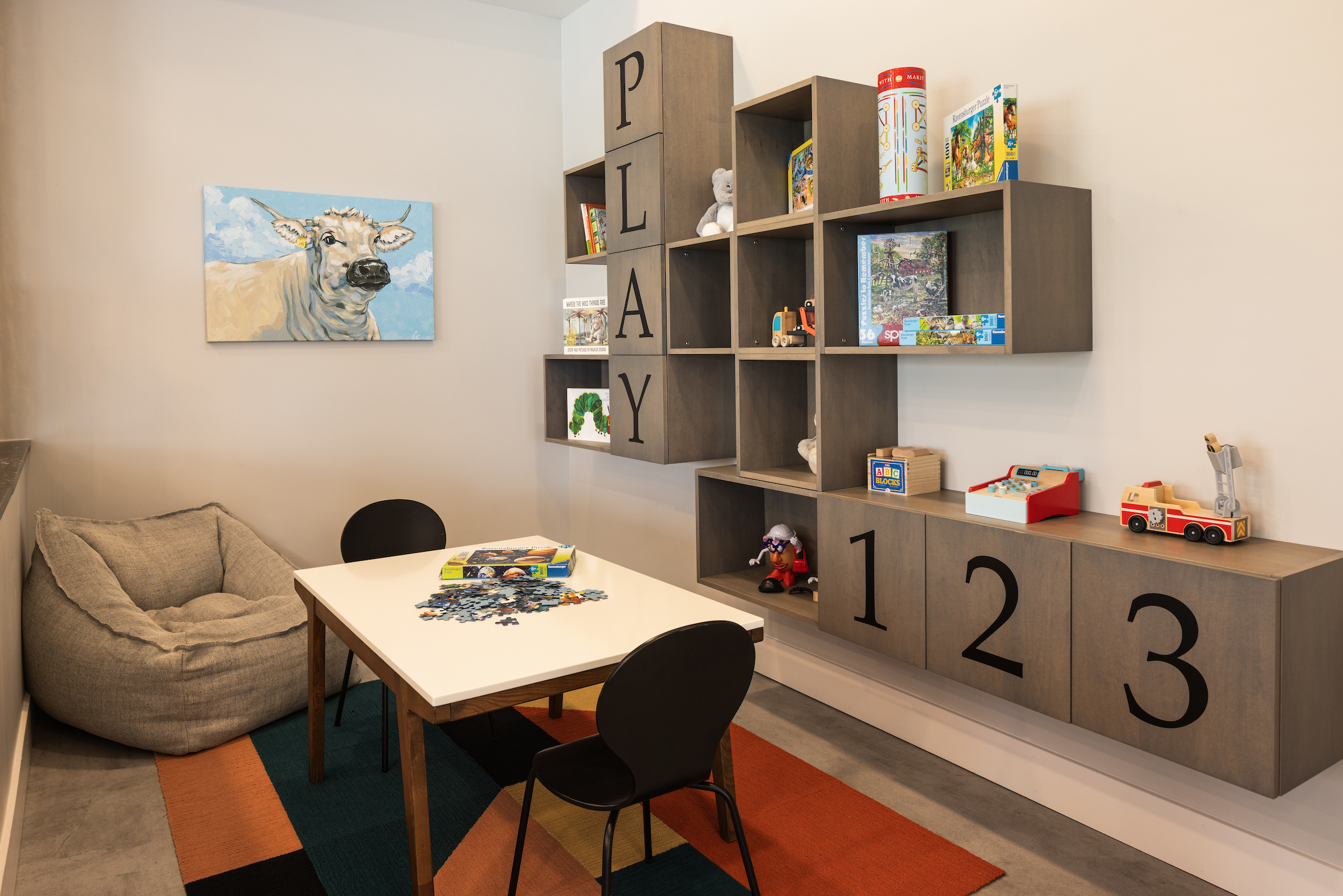 Slate apartments children's playroom amenity with games and seating.