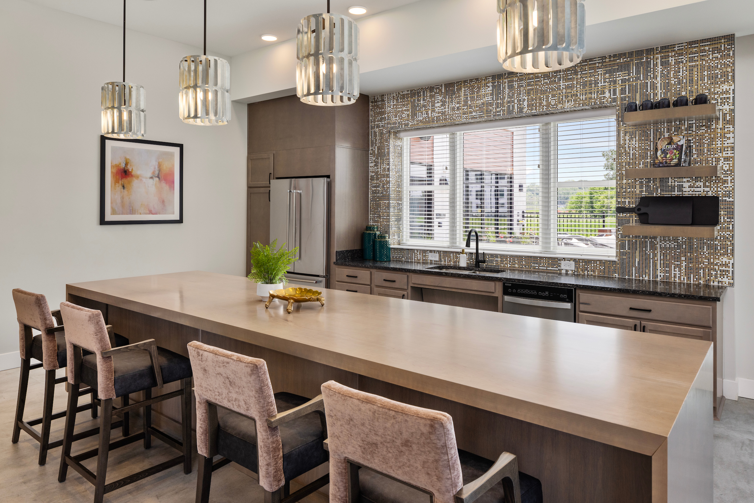 Slate apartments resident clubhouse dining area with kitchen and countertop seating.