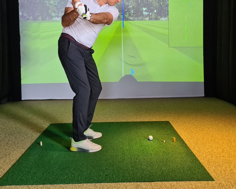 Senior man using the resident golf simulator amenity